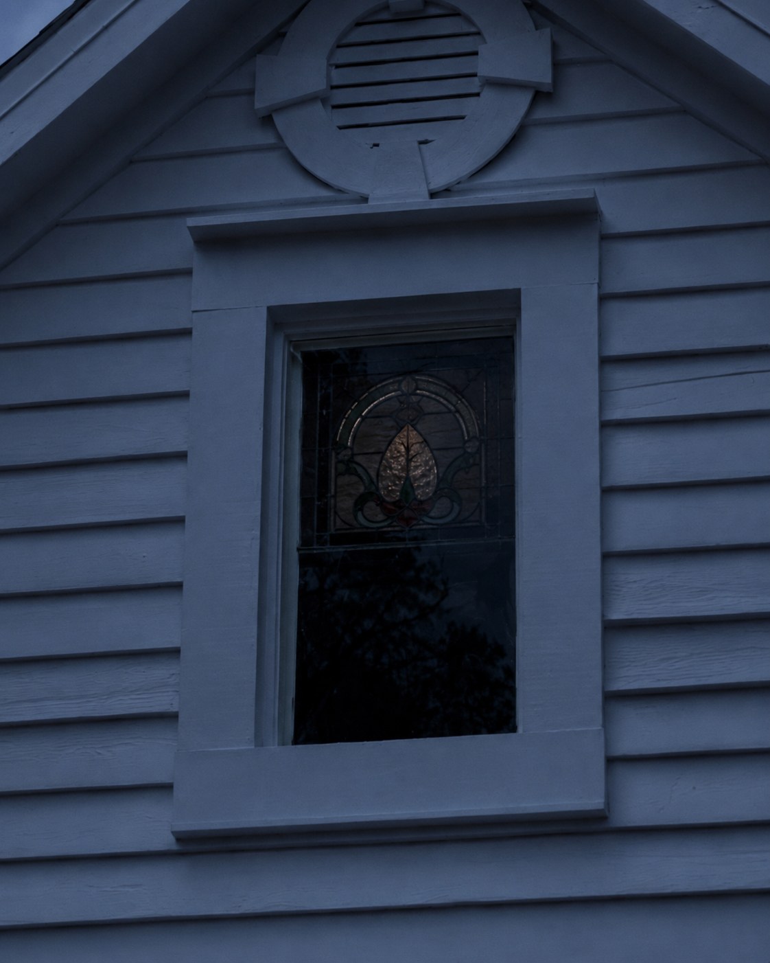 Dark upstairs window on a historic house.